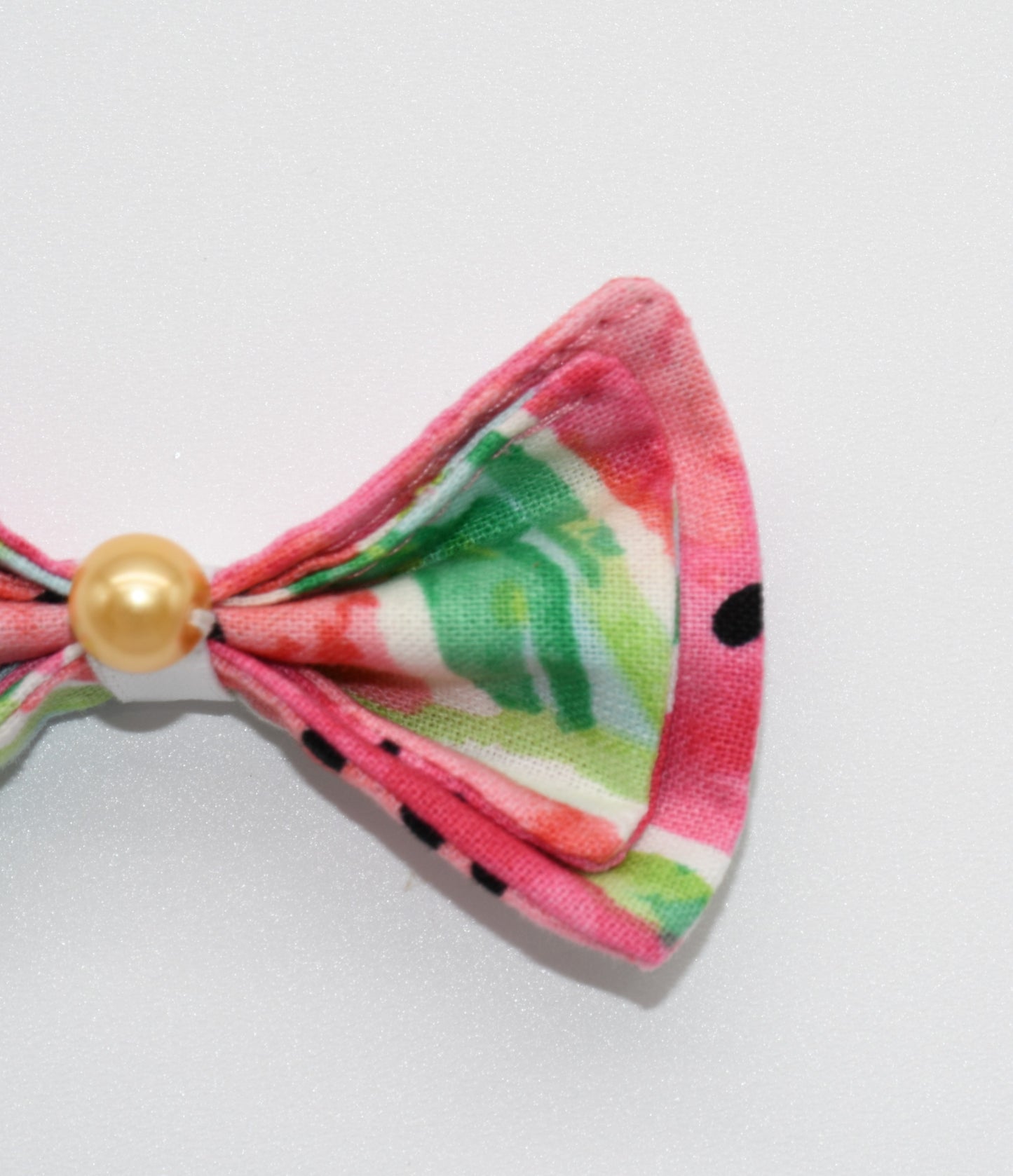 a watermelon pet hairbow with a gold pearl