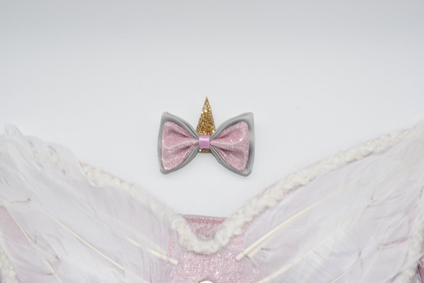 A close up at the unicorn hair bow and wings.