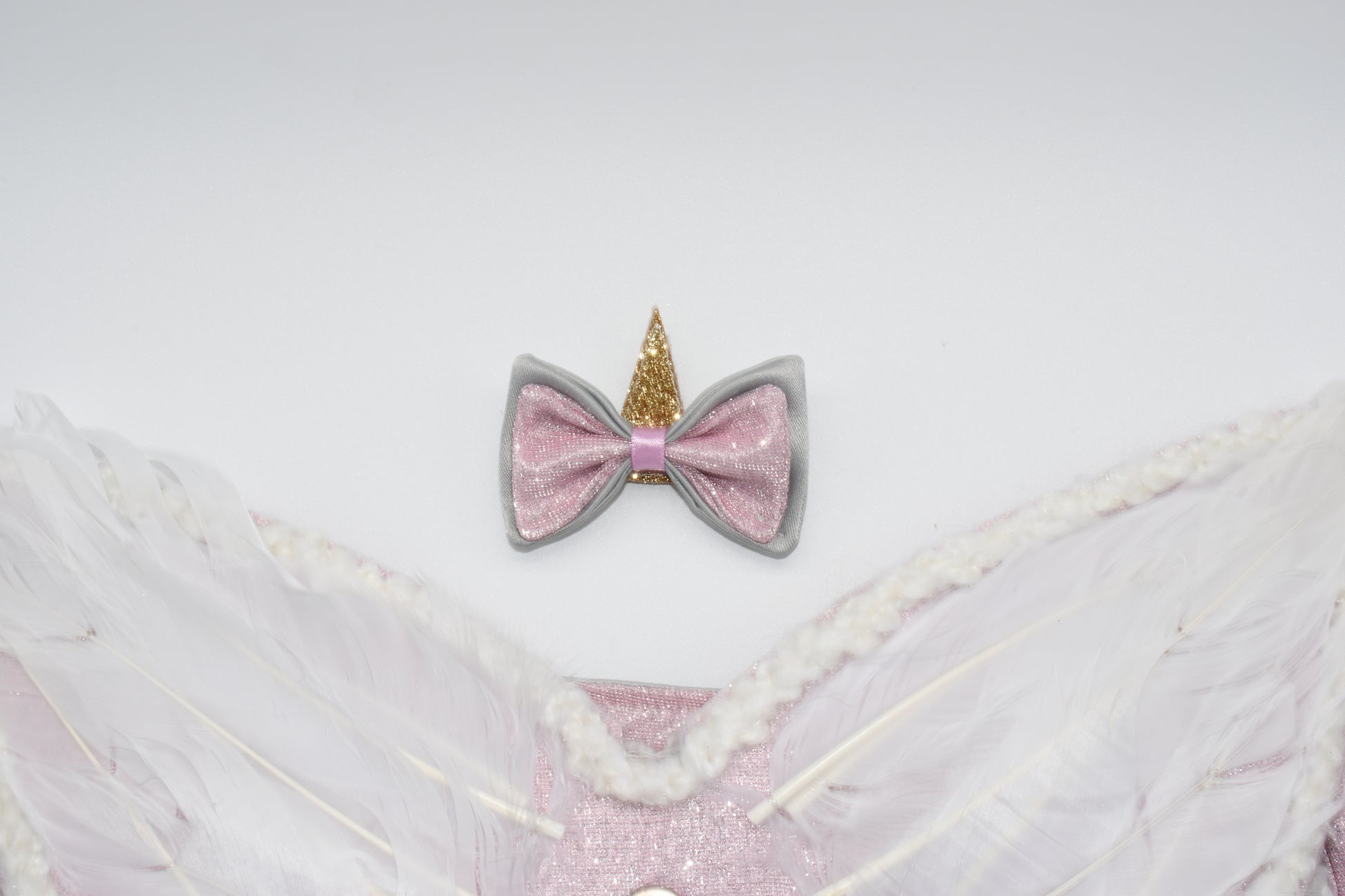 A close up at the unicorn hair bow and wings.